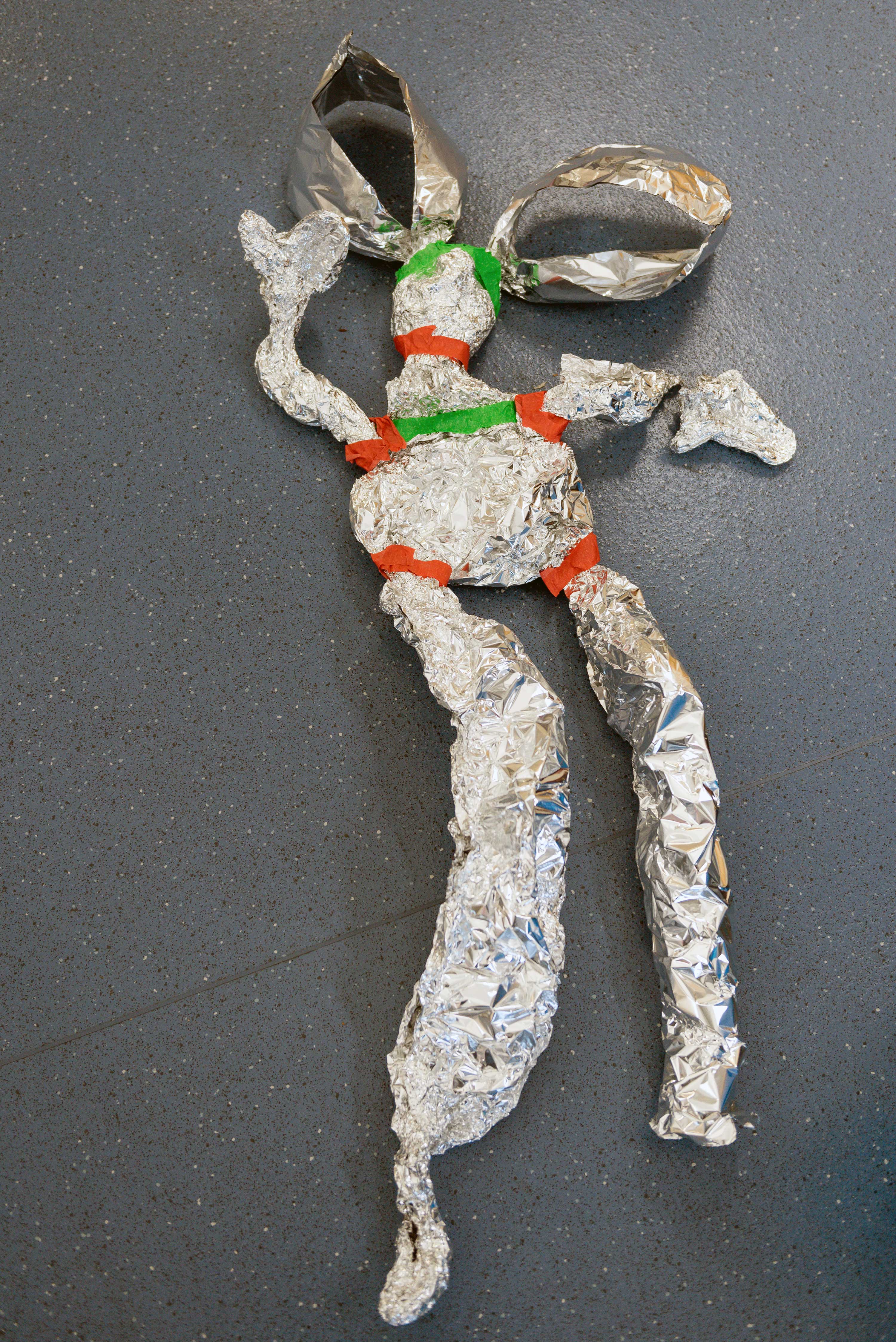 A large scale sculpture of a body made of foil