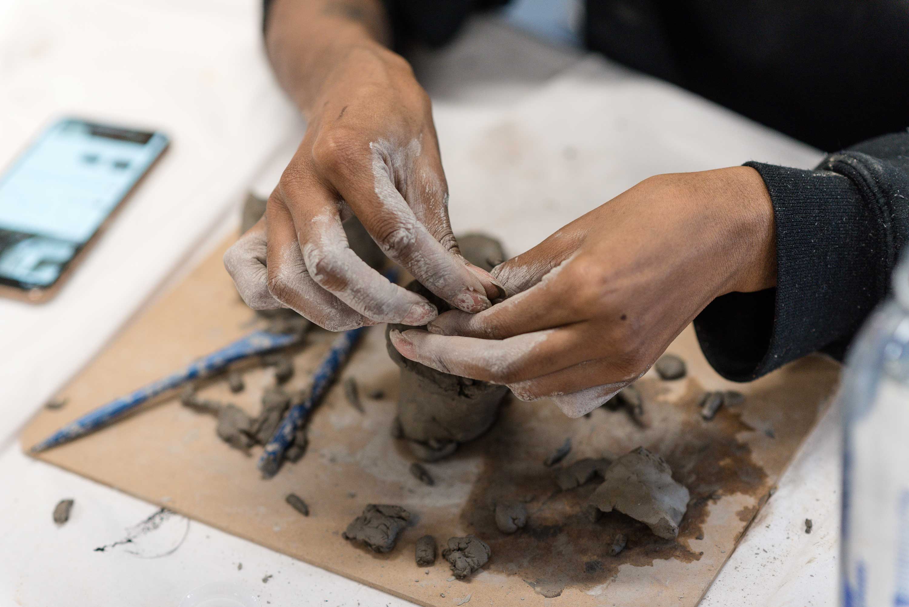 A close up of the participant using clay to create a sculpture