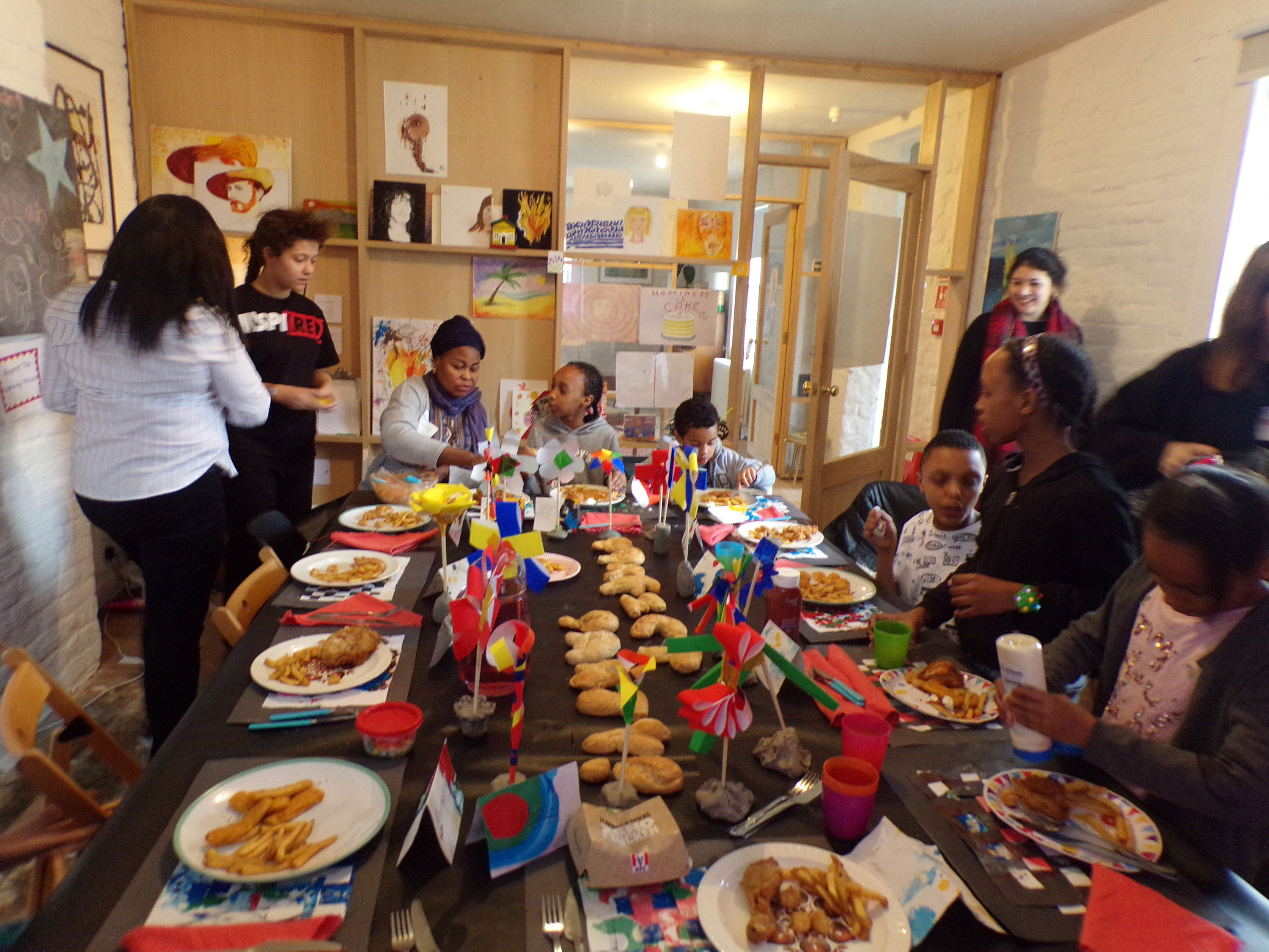 A group of participants gathered around a table decorated with party decorations and food