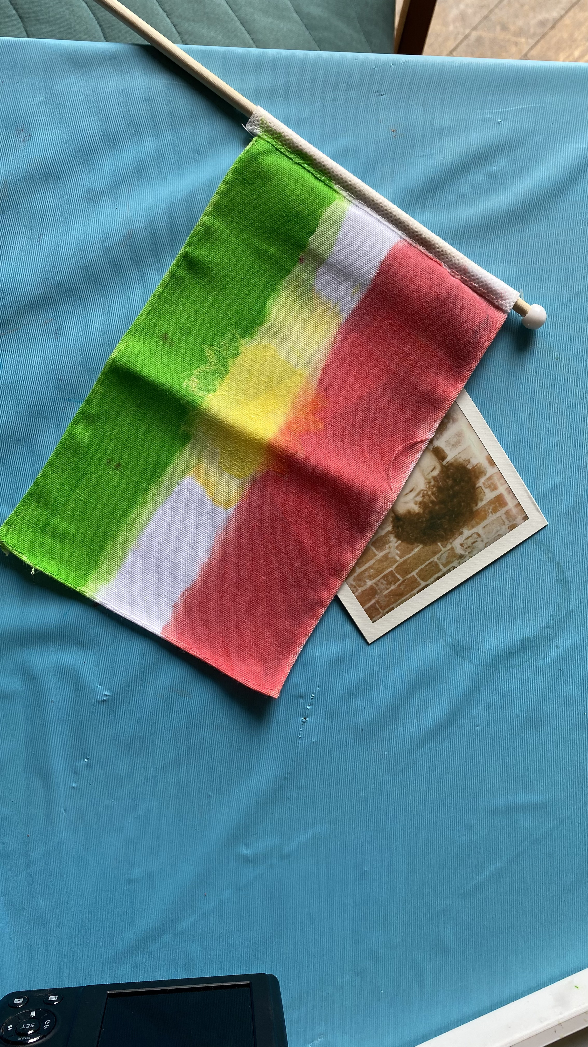 Flag laide onto blue cloth obscuring most of a colour photograph