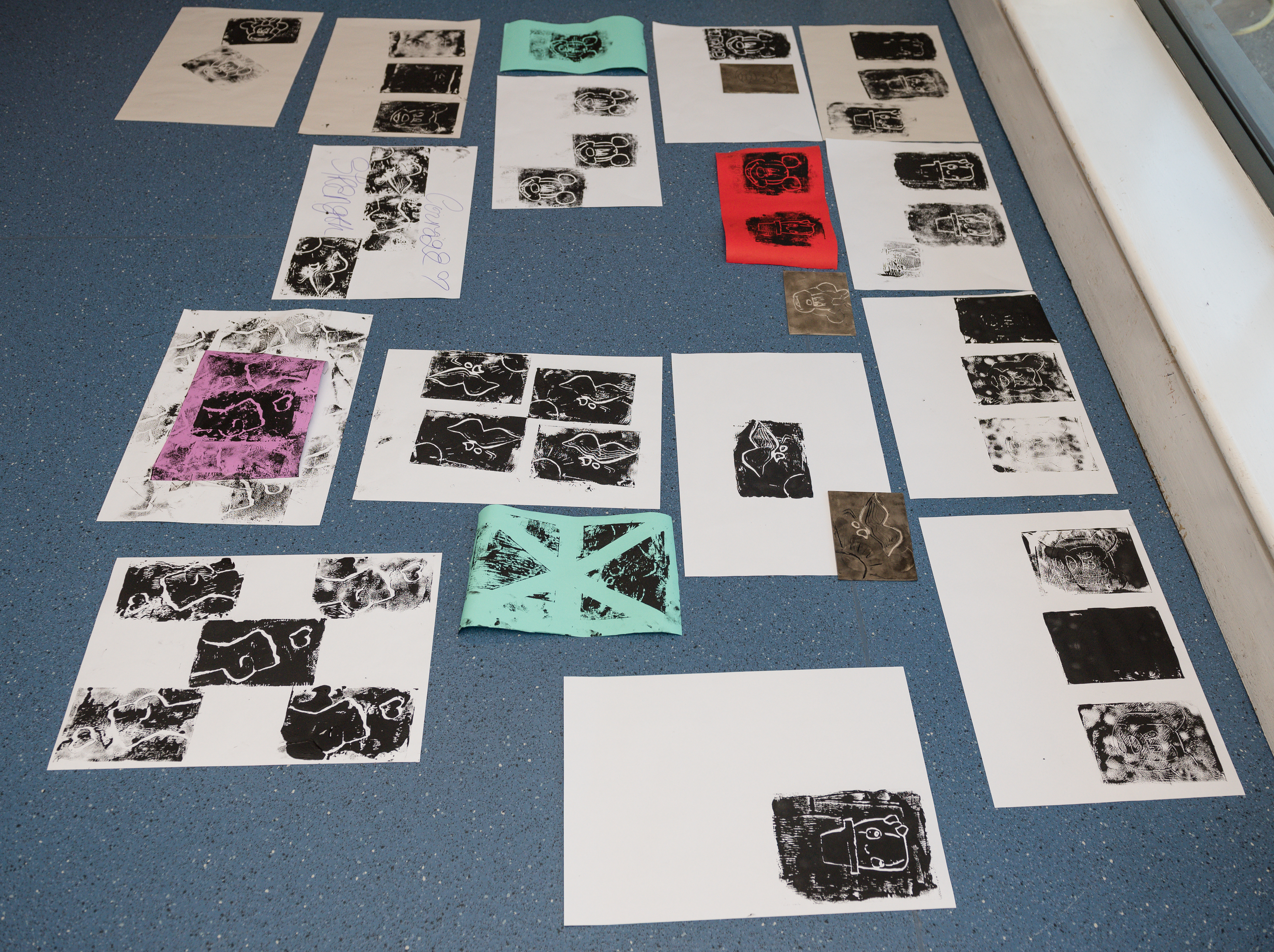 Images laid out on the floor of a studio space